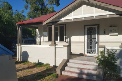 Imagen de fachada de casa beige clásica de tamaño medio de una planta con revestimientos combinados y tejado de metal