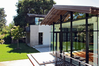 Свежая идея для дизайна: большой, двухэтажный, бежевый дом в современном стиле с облицовкой из бетона и двускатной крышей - отличное фото интерьера