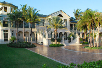 Example of a huge classic beige two-story brick exterior home design in Miami with a gambrel roof