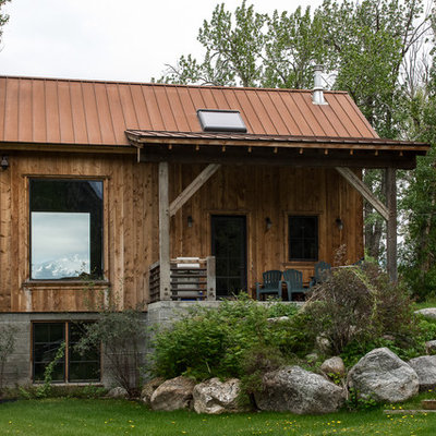 Mid-sized mountain style brown two-story wood house exterior photo in Other with a hip roof and a metal roof