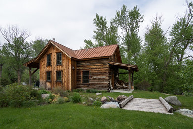 Idée de décoration pour une façade de maison marron chalet en bois de taille moyenne et à un étage avec un toit à deux pans et un toit en métal.
