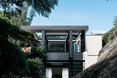 Diseño de fachada de casa negra contemporánea de tamaño medio de dos plantas con revestimiento de madera, tejado plano y tejado de metal