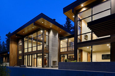 Aménagement d'une grande façade de maison marron moderne en bois à un étage avec un toit plat.