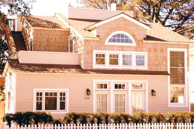 Modelo de fachada de casa beige marinera de tamaño medio de dos plantas con revestimiento de madera, tejado a dos aguas y tejado de teja de madera