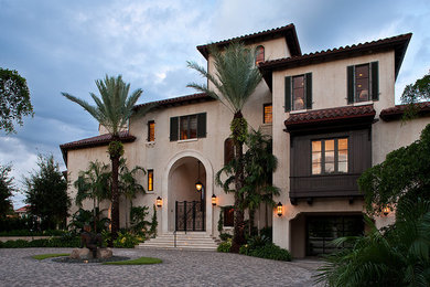 Expansive and beige mediterranean house exterior in Miami with three floors.