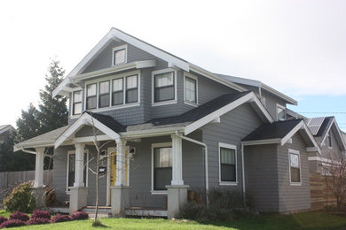 Ejemplo de fachada de casa gris de dos plantas con tejado de teja de madera