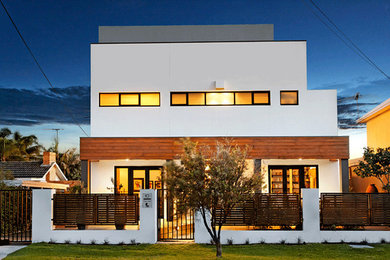 Foto della facciata di una casa bianca contemporanea a due piani con tetto piano