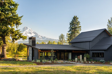 Inspiration for a large rustic black one-story wood house exterior remodel in Portland with a shed roof and a metal roof