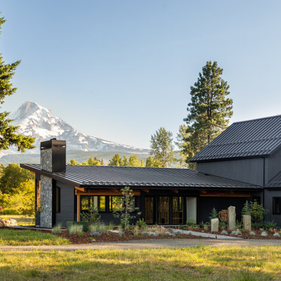 Inspiration for a large rustic black one-story wood house exterior remodel in Portland with a shed roof and a metal roof
