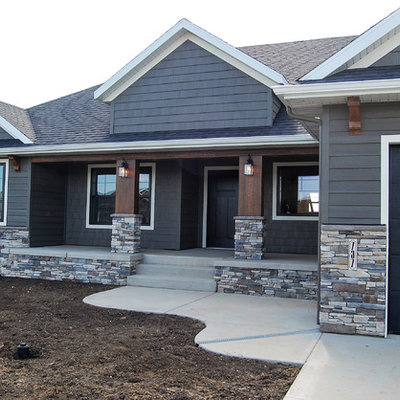 Example of a mid-sized classic gray one-story concrete fiberboard house exterior design in Other with a gambrel roof and a shingle roof