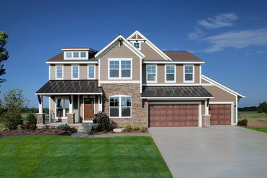 Photo of a medium sized and beige traditional two floor detached house in Grand Rapids with mixed cladding, a pitched roof and a metal roof.