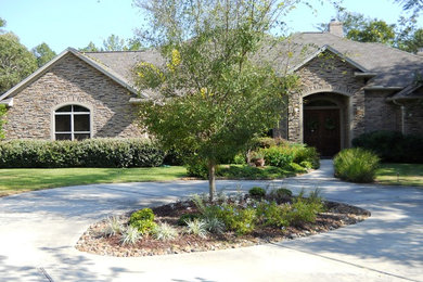 Expansive and beige classic bungalow house exterior in Houston with stone cladding and a pitched roof.