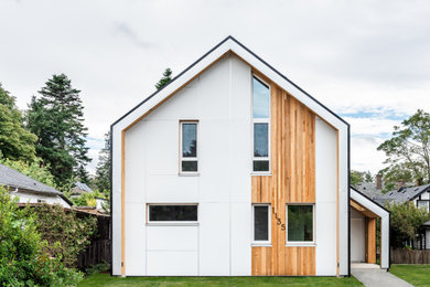 Foto de fachada de casa blanca nórdica pequeña de dos plantas con revestimiento de metal, tejado a dos aguas y tejado de metal