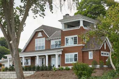 Imagen de fachada de casa marrón y marrón clásica de tamaño medio de dos plantas con revestimiento de madera, tejado a cuatro aguas, tejado de teja de madera y teja