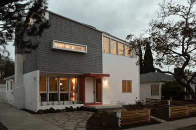 Ejemplo de fachada gris moderna de dos plantas con revestimientos combinados y tejado a dos aguas