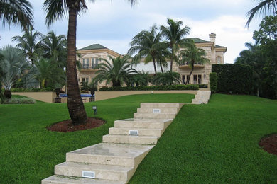 Diseño de fachada de casa beige mediterránea extra grande de dos plantas con revestimiento de piedra y tejado a cuatro aguas