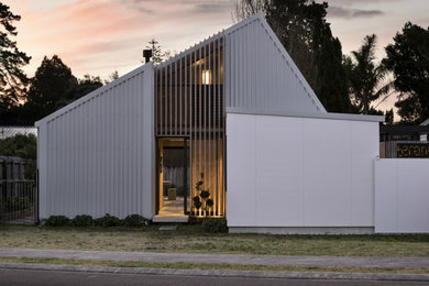 Modelo de fachada de casa gris actual de dos plantas con revestimiento de metal