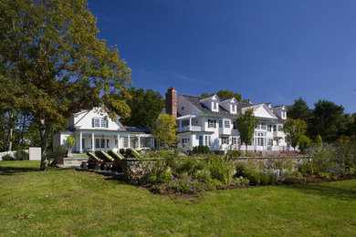 Example of a huge classic three-story wood exterior home design in New York