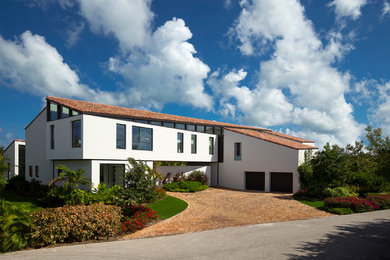 Modelo de fachada de casa blanca mediterránea grande de dos plantas con revestimiento de estuco y tejado de teja de barro