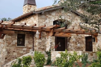 Inspiration for a large mediterranean beige one-story stone exterior home remodel in San Francisco with a hip roof