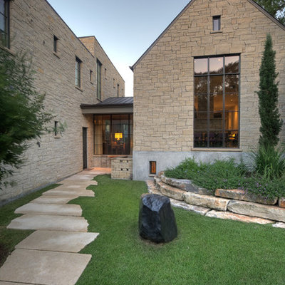 Large elegant two-story stone exterior home photo in Austin