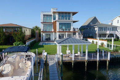Inspiration for a large modern gray three-story wood flat roof remodel in Wilmington