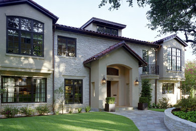 Large elegant beige three-story mixed siding exterior home photo in Austin with a tile roof