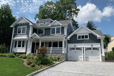 Example of a large classic blue two-story vinyl exterior home design in New York with a shingle roof