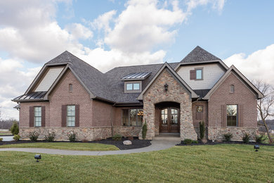 Example of a large transitional brown one-story brick exterior home design in Cincinnati with a clipped gable roof