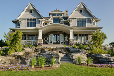 Large transitional beige three-story stone house exterior photo in Other