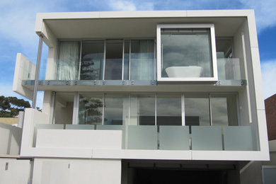 Diseño de fachada blanca contemporánea grande de tres plantas con revestimiento de estuco