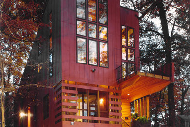 Idée de décoration pour une façade de maison rouge minimaliste en panneau de béton fibré de taille moyenne et à deux étages et plus avec un toit en appentis.