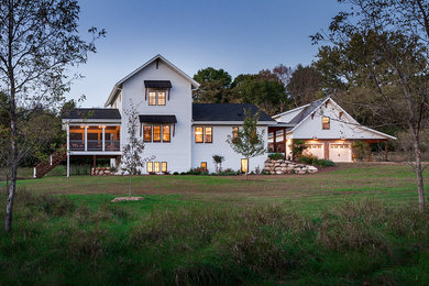 Inspiration for a mid-sized country white two-story wood exterior home remodel in Minneapolis with a mixed material roof