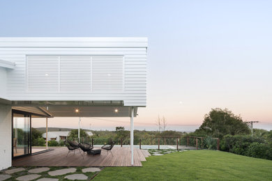 Foto de fachada de casa blanca costera pequeña de una planta con revestimientos combinados, tejado a dos aguas y tejado de metal