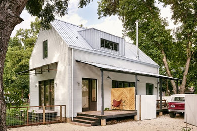 Example of a small farmhouse white two-story metal gable roof design in Austin