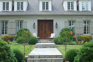 Ejemplo de fachada gris tradicional de tamaño medio de dos plantas con revestimiento de ladrillo y tejado a dos aguas