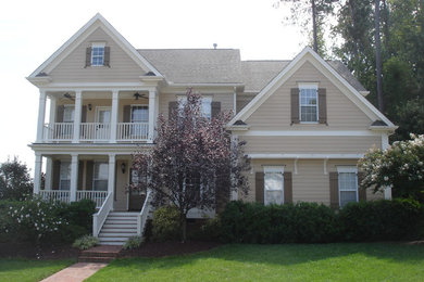 Example of a large arts and crafts beige two-story wood exterior home design in Raleigh