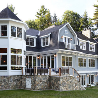 Inspiration pour une très grand façade de maison bleue traditionnelle à deux étages et plus avec un toit de Gambrel, un revêtement en panneau de béton fibré et un toit en shingle.