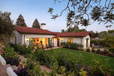 Large tuscan white one-story stucco exterior home photo in Santa Barbara with a tile roof