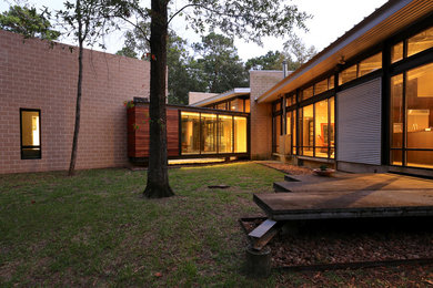 Example of a mid-sized minimalist one-story mixed siding house exterior design in Houston with a shed roof and a metal roof