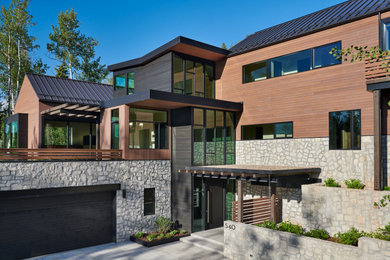 Modelo de fachada de casa multicolor contemporánea extra grande de tres plantas con tejado de metal, revestimientos combinados y tejado a cuatro aguas