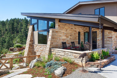 Inspiration for a mid-sized modern beige two-story stone exterior home remodel in Denver with a shed roof