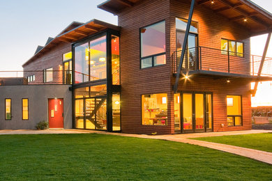 Aménagement d'une grande façade de maison multicolore industrielle à un étage avec un revêtement mixte, un toit en appentis et un toit en métal.