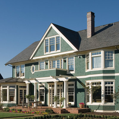 Large elegant green three-story wood exterior home photo in St Louis