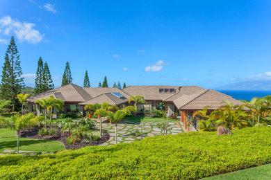 Huge tropical gray one-story concrete house exterior idea in Hawaii with a shingle roof