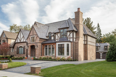 Ispirazione per la villa ampia beige classica a due piani con rivestimento in mattoni, tetto a padiglione e copertura a scandole