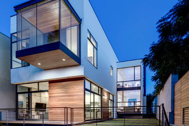 Imagen de fachada blanca minimalista grande de dos plantas con revestimiento de estuco y tejado plano