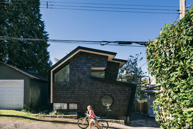 Photo of a small and gey contemporary two floor house exterior in Vancouver with wood cladding.