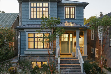 Exemple d'une façade de maison bleue chic en bois de taille moyenne et à un étage avec un toit à quatre pans et un toit en métal.