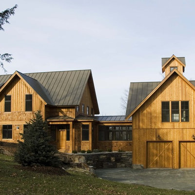 Inspiration for a country three-story wood exterior home remodel in Burlington with a metal roof